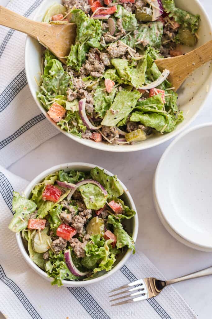 overview of a burger salad with pickles and red onion