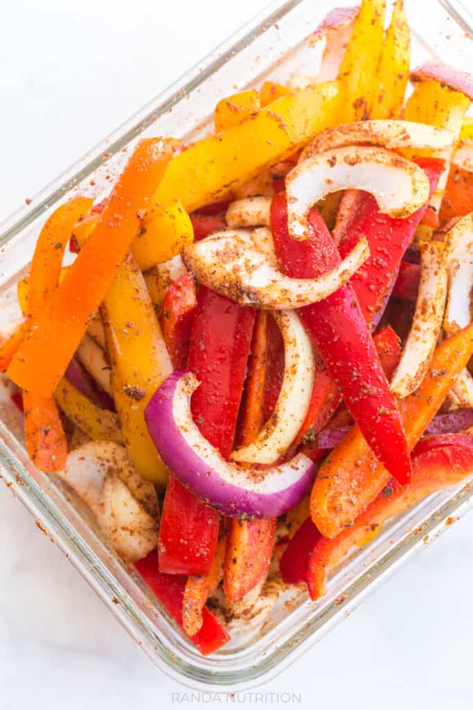 a closeup of the vegetables marinating in the dry rub marinade for this Chicken Fajita Bake Recipe