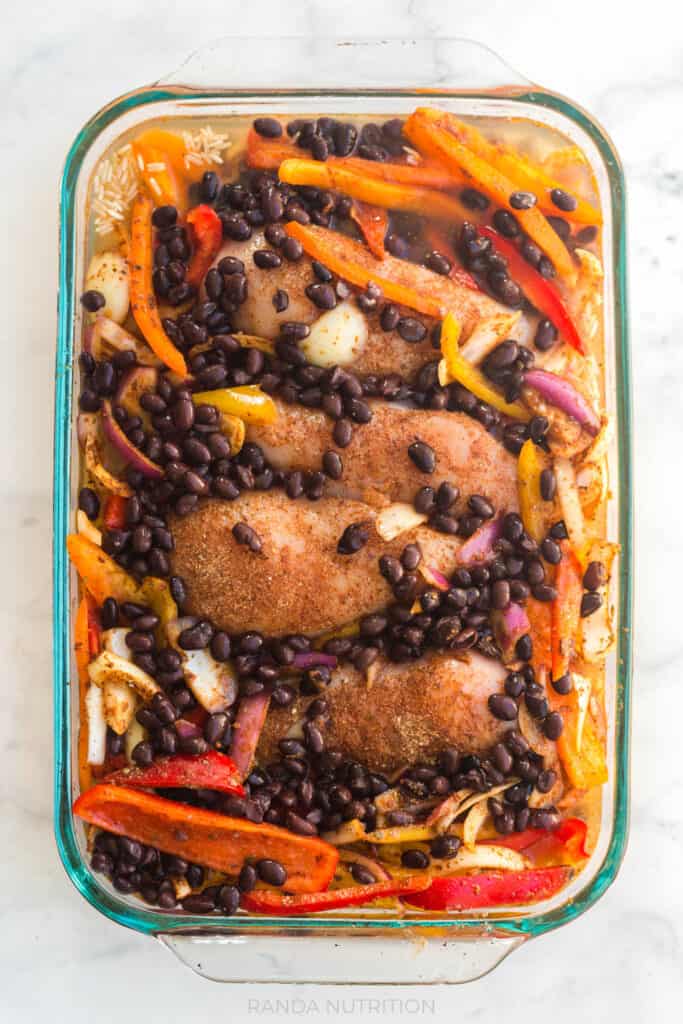 an overhead view of this uncooked Chicken Fajita Bake Recipe inside of a glass casserole dish