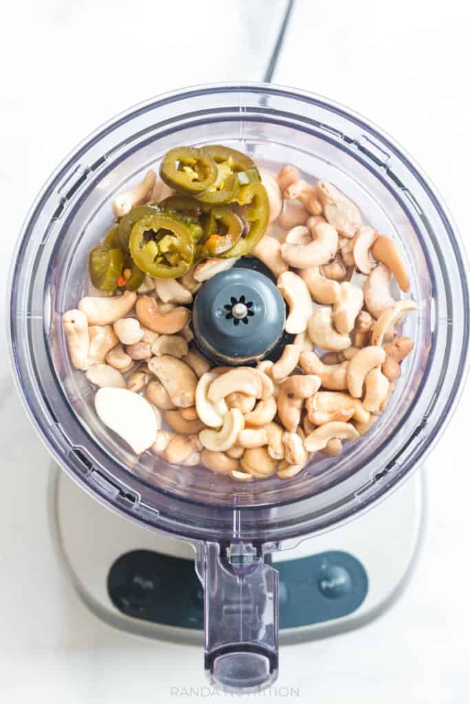 pickled jalapenos, cashews, lime juice, garlic in a food processor ready to make sauce