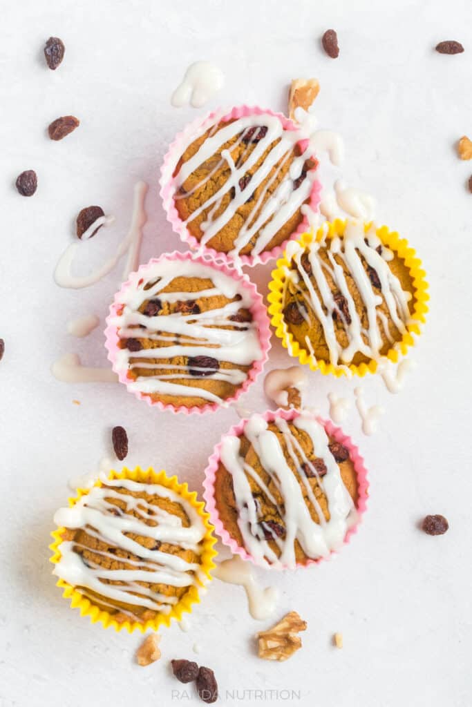 over top view of muffins with a greek yogurt drizzle and raisins