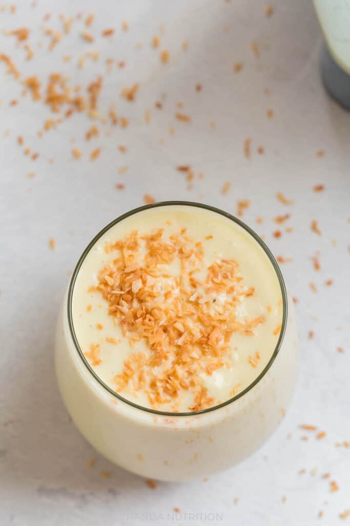 overhead view of tropical avocado smoothie with toasted coconut