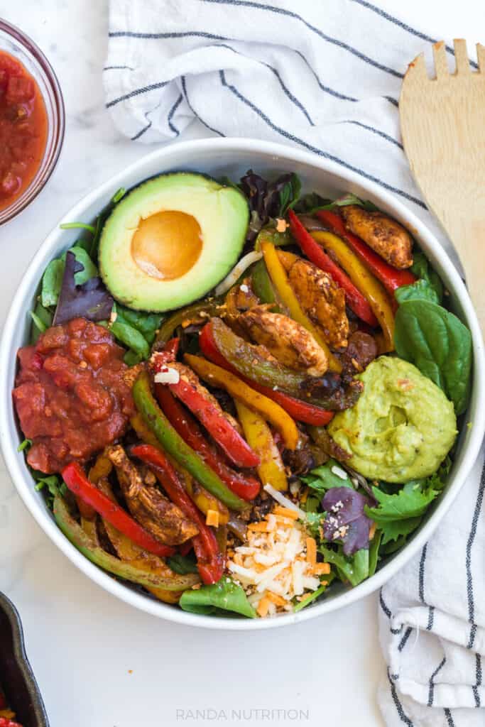 salad with chicken, bell peppers, guacamole, and salsa