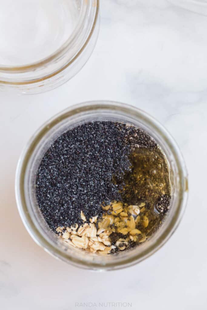 chia seeds, poppy seeds, and oats with honey mixed in a mason jar
