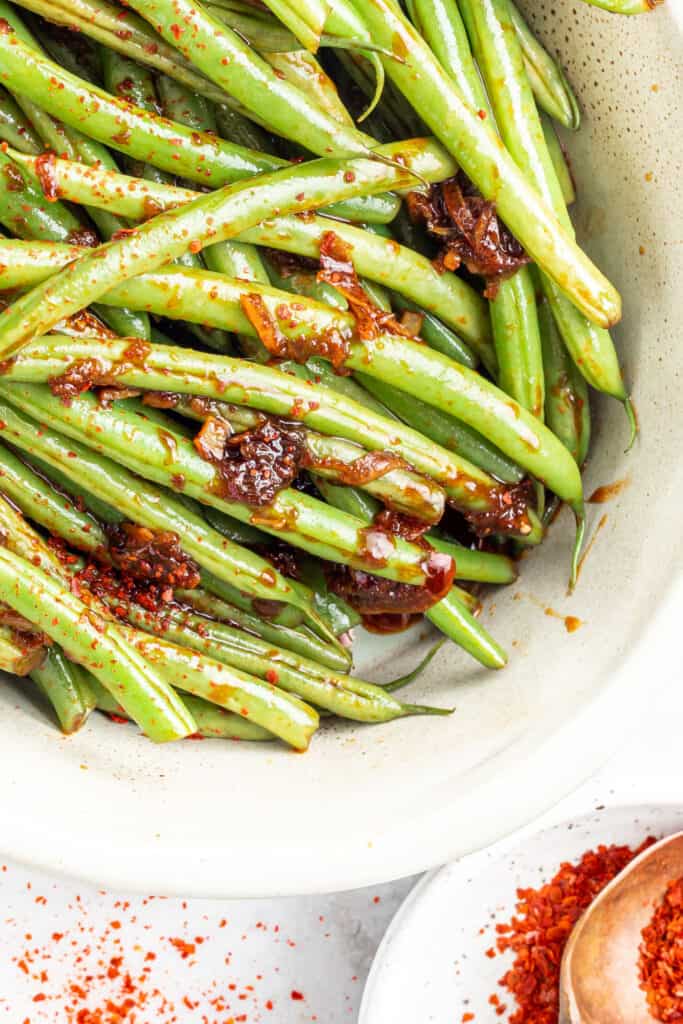 spicy beans in a casserole dish with chili sauce over it