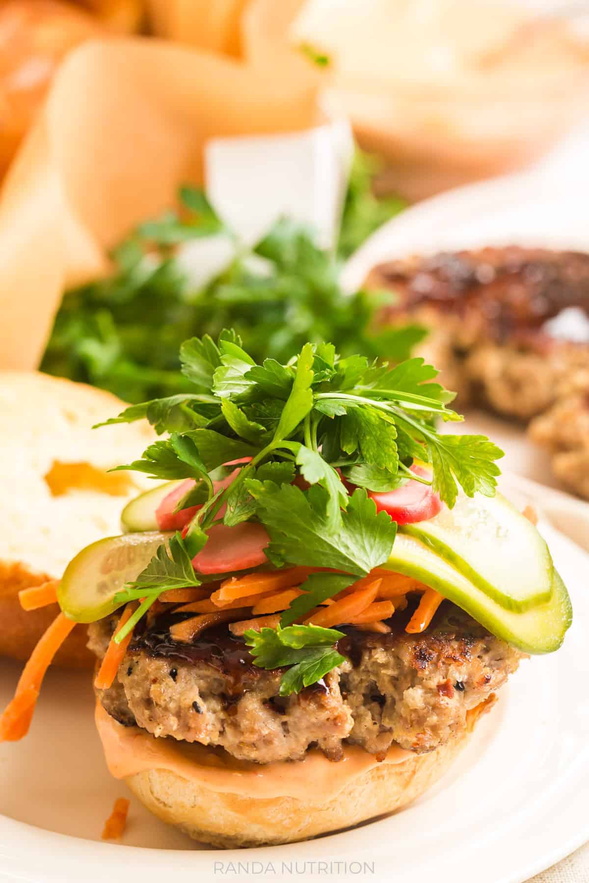 ground pork burger topped with hoisin sauce and pickled vegetables