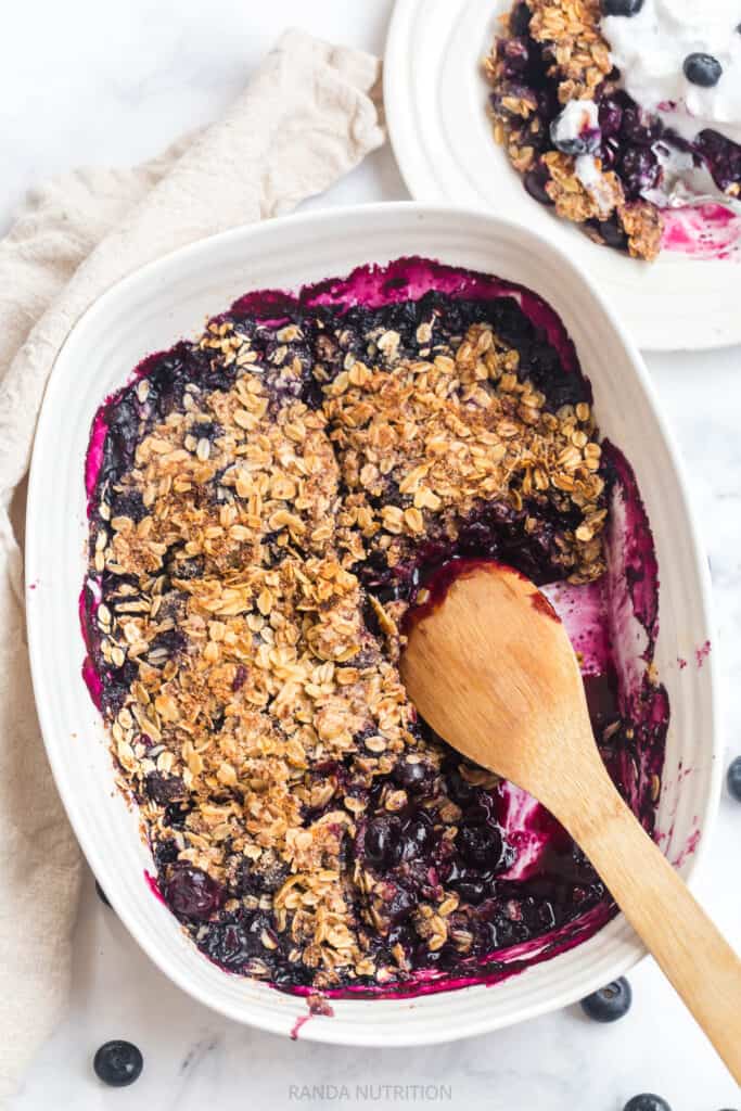 gluten free blueberry crisp with a wooden spoon