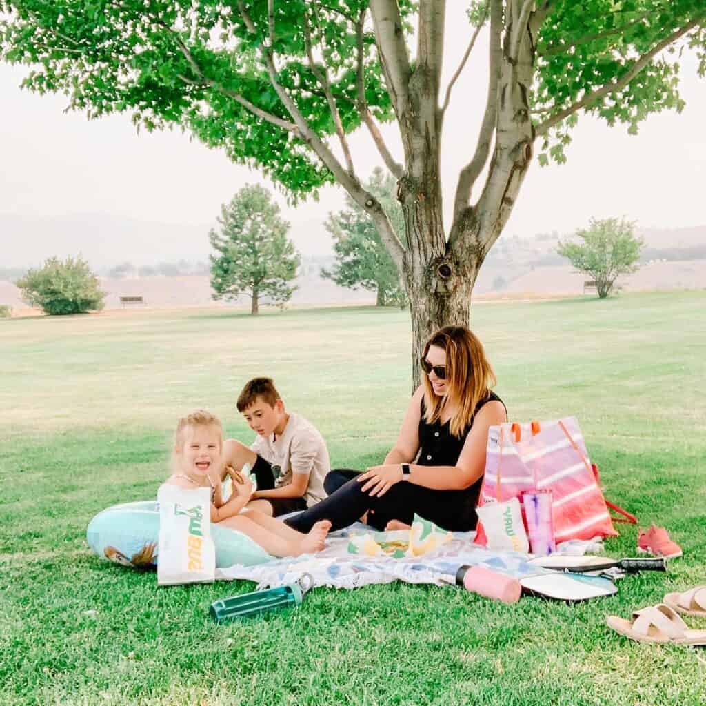 family sitting in a park eating subway