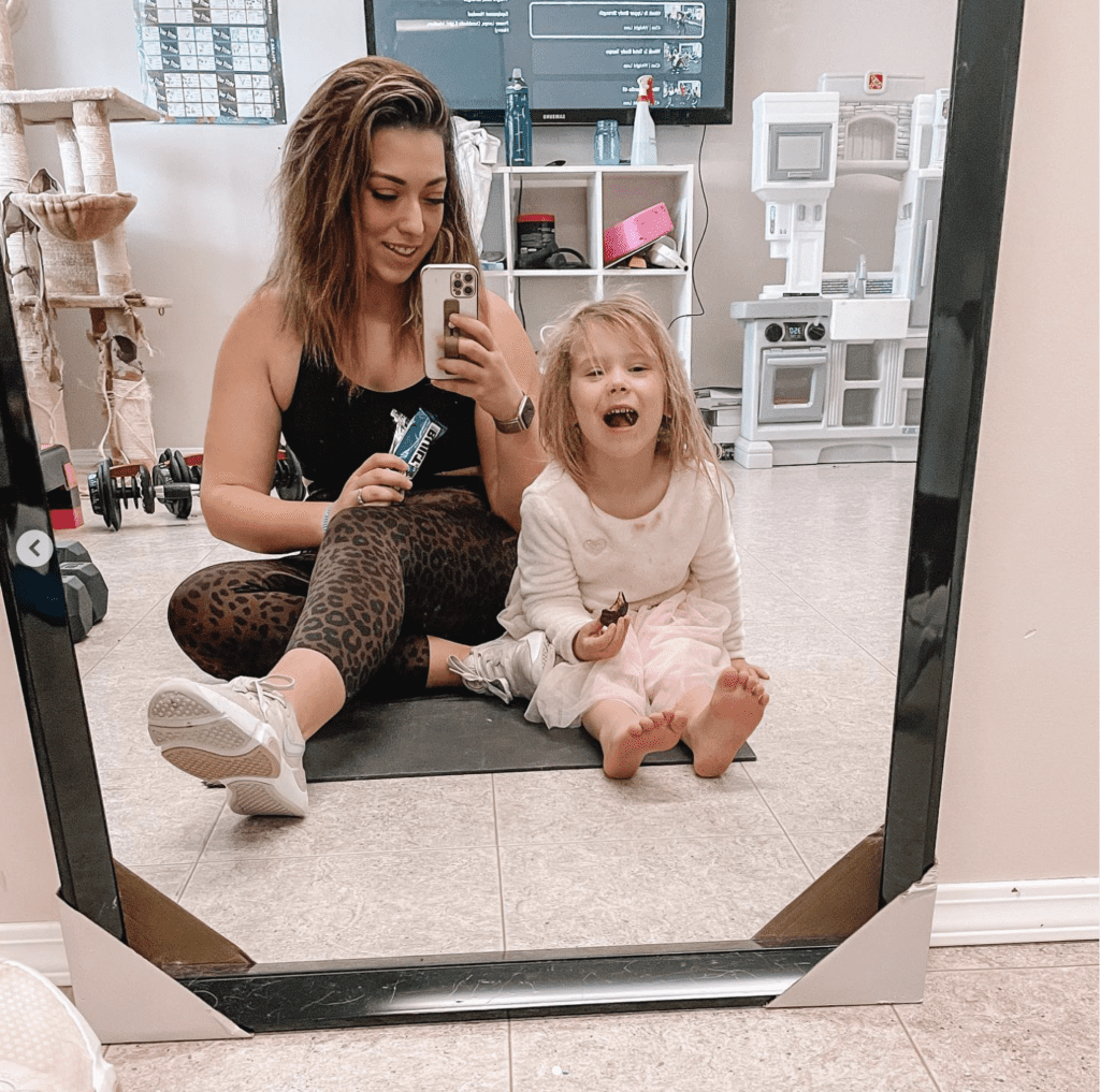 randa derkson with daughter having a built bar after a workout