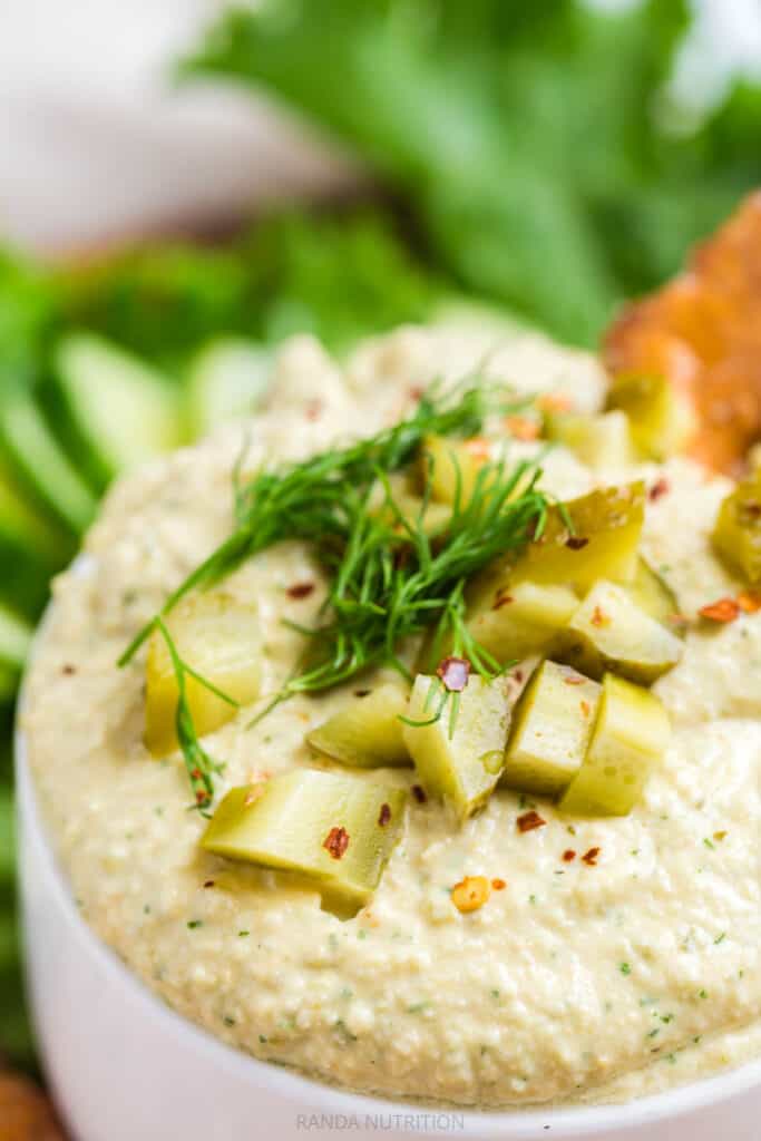 chopped pickles and fresh dill over top hummus