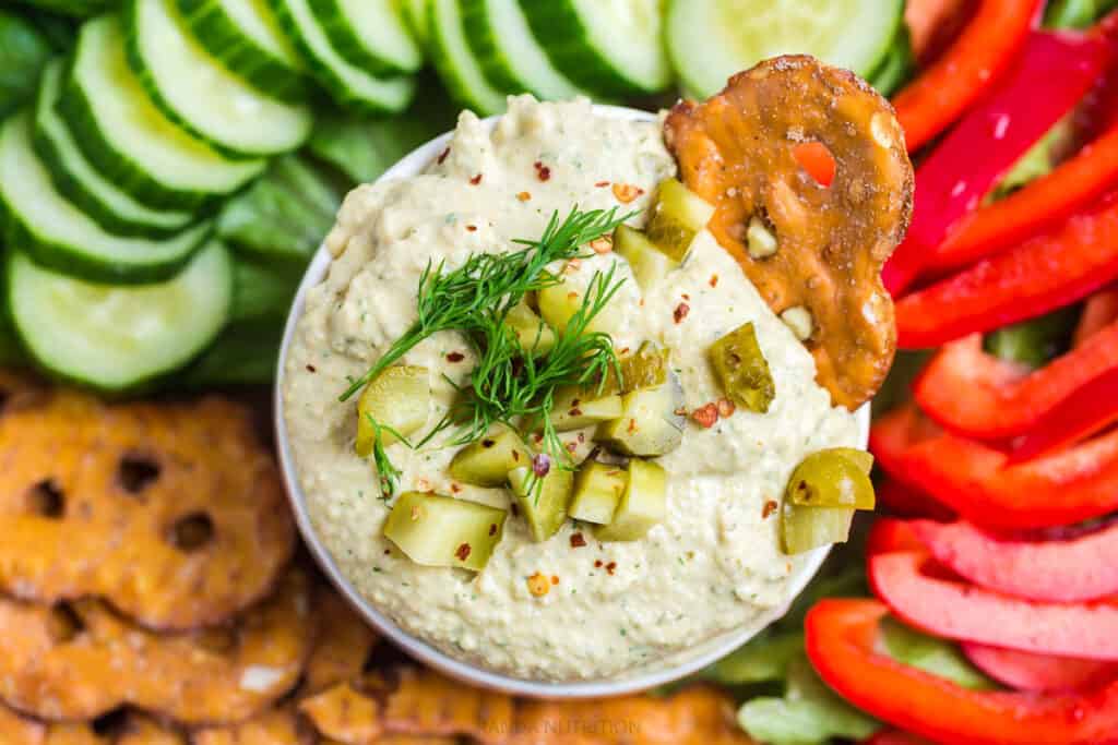 fresh herbs overtop homemade dill pickle hummus