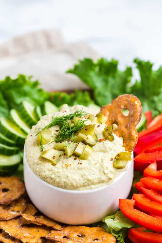 dill pickle hummus with pretzel chips dipped