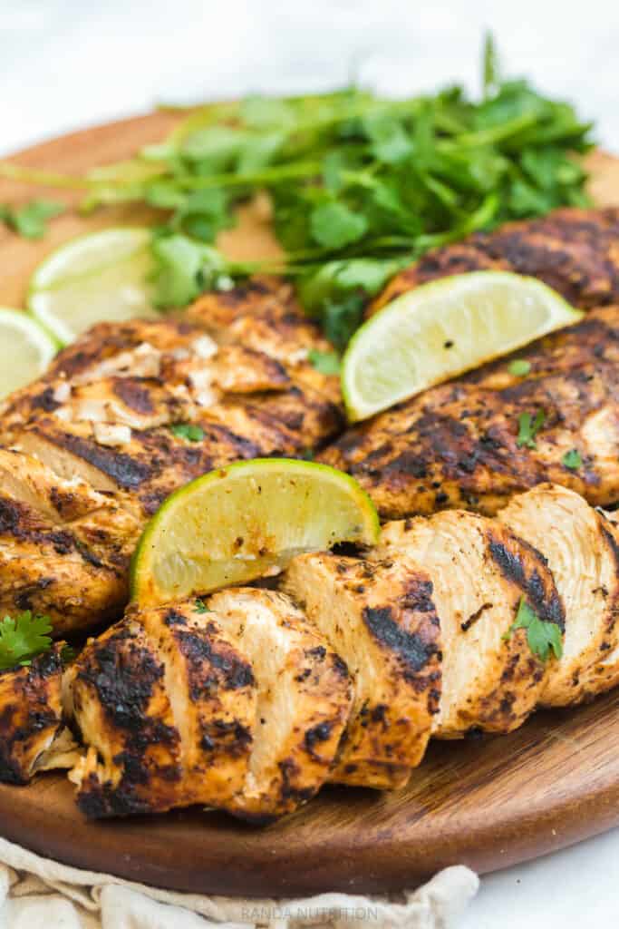 sliced chicken breast on a cutting board with mexican spices and lime