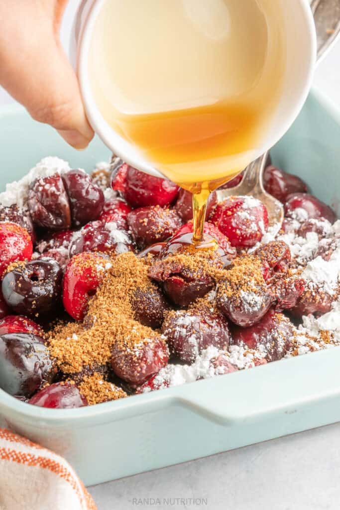 pouring maple syrup over cherries