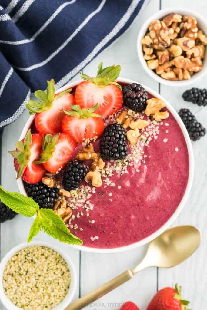 mixed berry smoothie bowl with blackberries and sliced strawberries and hemp seeds on top