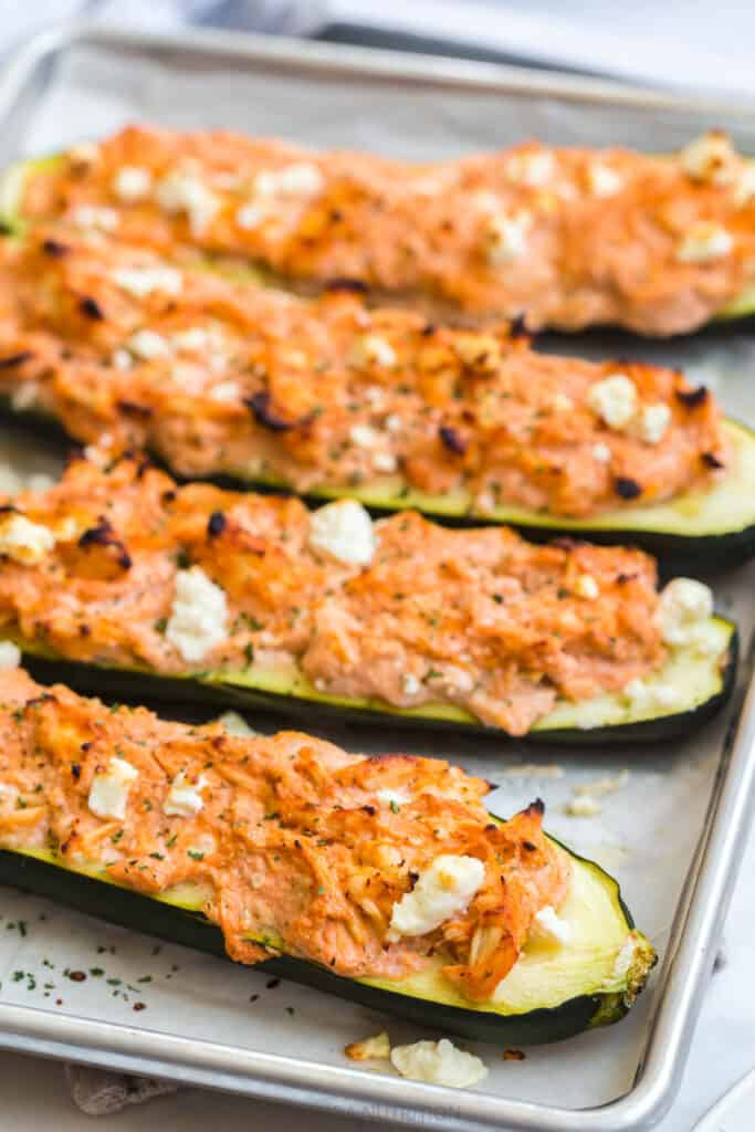 roasted zucchini on a sheet pan with a buffalo chicken filling