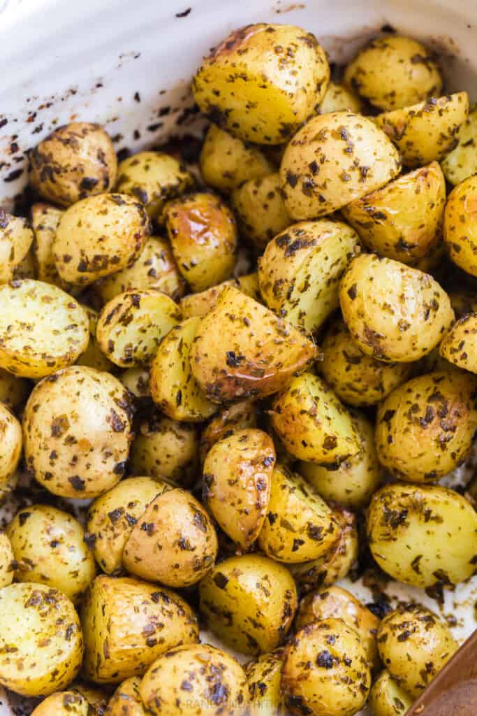 close up of roasted potatoes with herbs and. garlic overtop