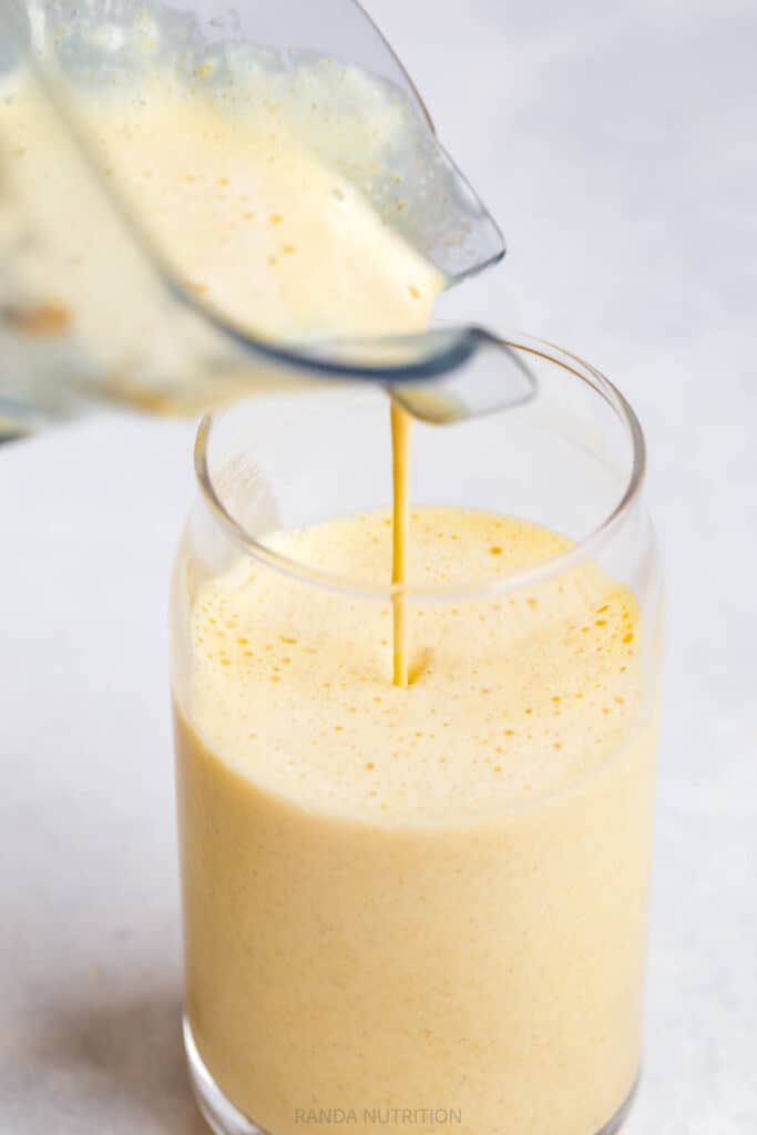 pouring a smoothie in a soda can shaped glass