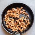 searing chicken thighs in a skillet