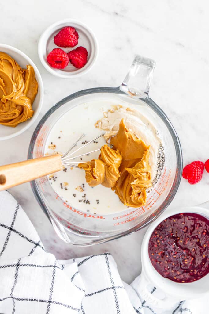 adding peanut butter, chia seeds and milk to a large mixing bowl