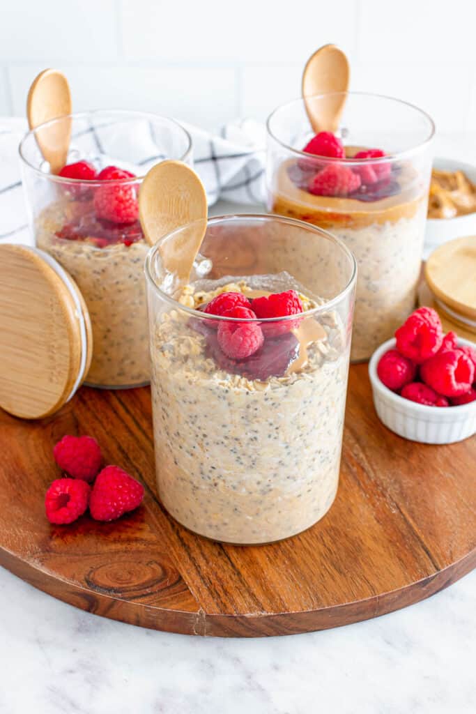 peanut butter and jelly oats in a meal prep container with fresh raspberries on top