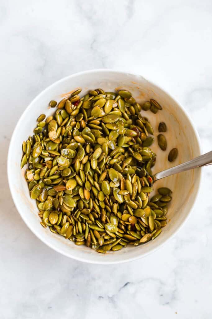 mixing pepitas with sweet thai chili sauce and seasonings