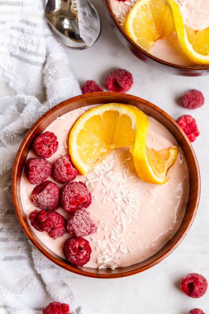 protein cottage cheese bowls topped with frozen rapsberries, lemon, and coconut shreds