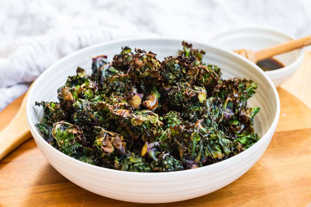 a bowl with roasted kale sprouts drizzled with balsamic glaze