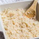 Oven baked rice stirred and fluffed with a wooden spoon