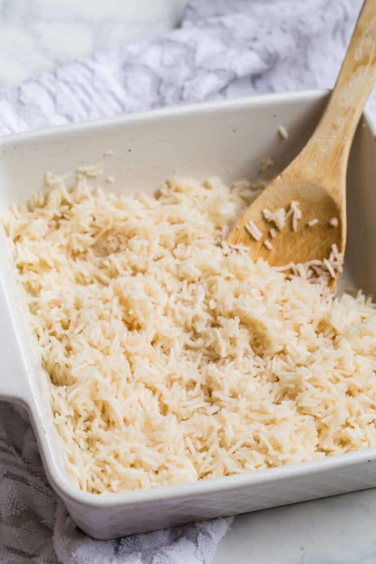 Oven baked rice stirred and fluffed with a wooden spoon