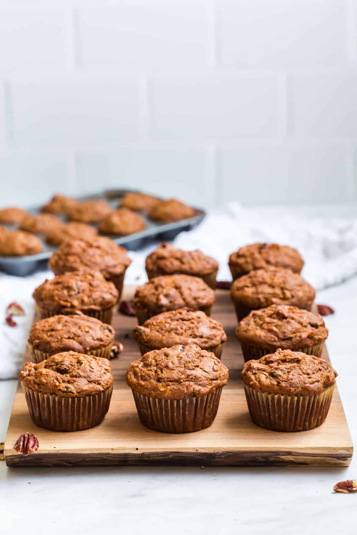 Gluten Free Morning Glory Muffins (Healthy & Moist) 9 Gluten free morning glory muffins arranged on a wooden board, freshly baked and ready to serve.