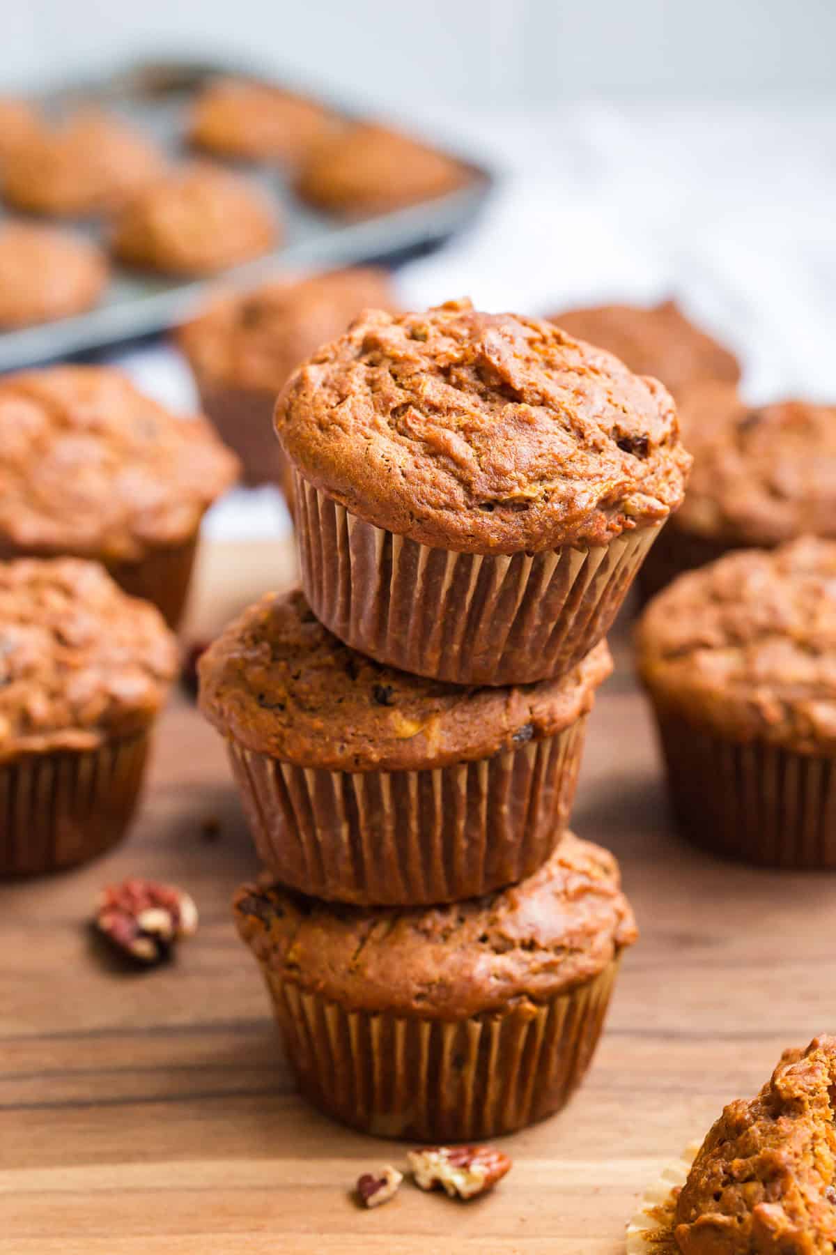 Gluten Free Morning Glory Muffins (Healthy & Moist) 1 Gluten free morning glory muffins made with carrots, apple, warm spices, and pecans stacked on a wooden board.