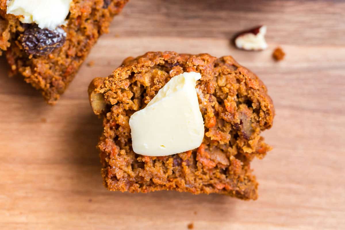 Gluten Free Morning Glory Muffins (Healthy & Moist) 14 Gluten free morning glory muffin cut in half with butter on top, showing a soft carrot apple muffin texture.