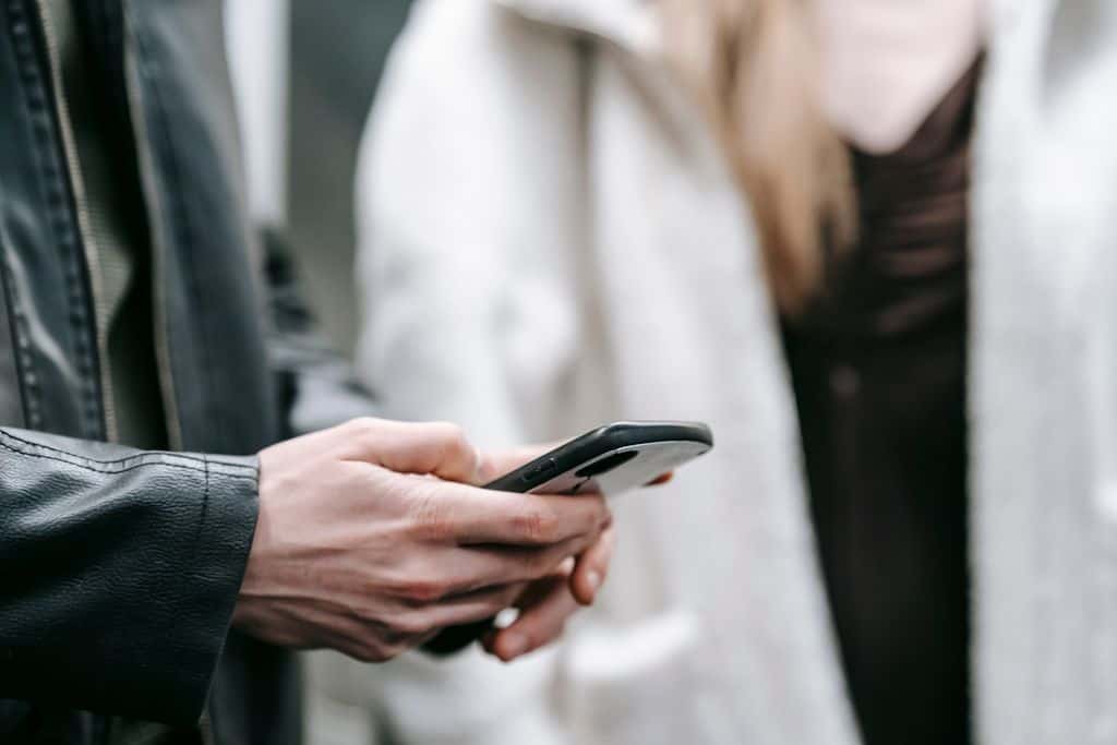 Forme Pilates & Nutrition Vernon BC 4 Crop faceless couple in warm clothes standing together while text messaging on phone